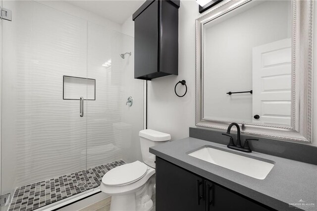 bathroom featuring an enclosed shower, vanity, and toilet