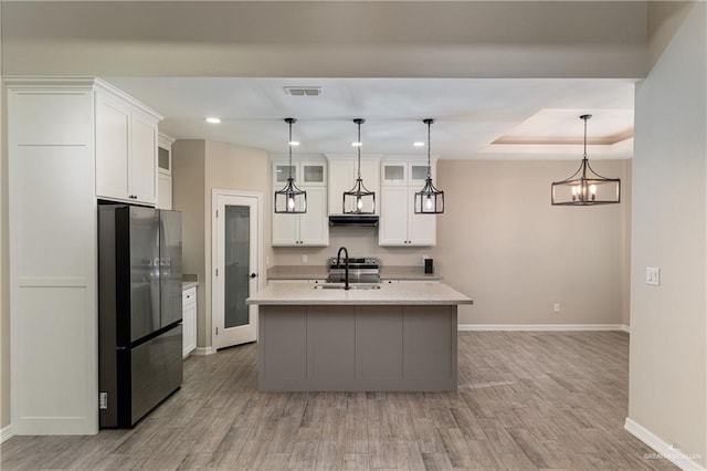 kitchen featuring visible vents, appliances with stainless steel finishes, light countertops, white cabinetry, and a sink