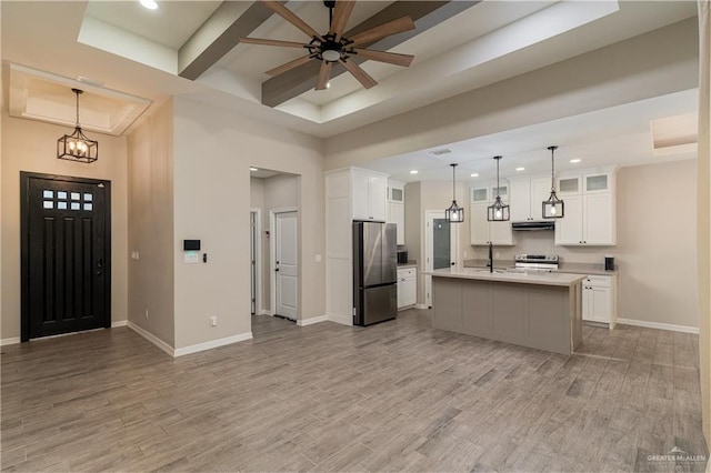 kitchen with appliances with stainless steel finishes, light wood-type flooring, light countertops, and baseboards