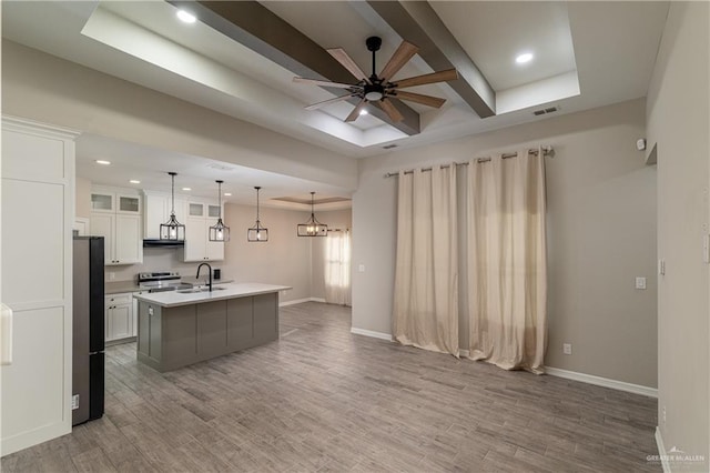 kitchen featuring freestanding refrigerator, a sink, wood finished floors, stainless steel electric range, and ceiling fan with notable chandelier