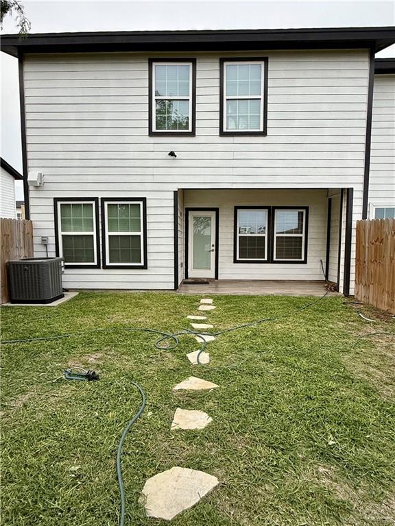 rear view of property with fence, a patio, a lawn, and cooling unit