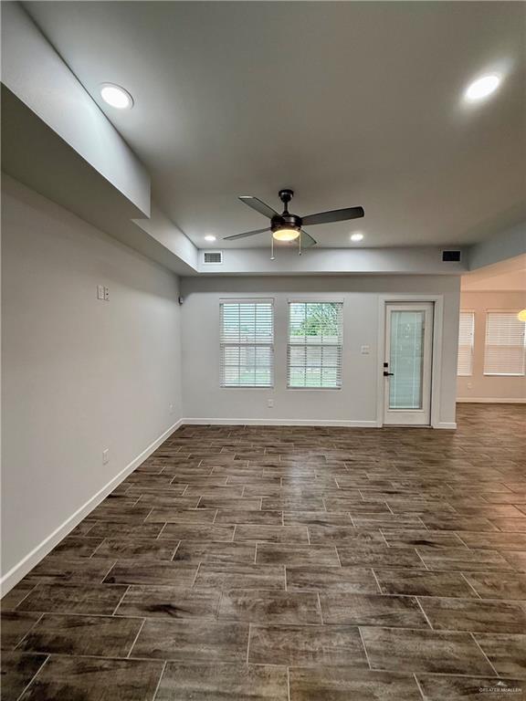 unfurnished room with visible vents, baseboards, wood finish floors, recessed lighting, and a ceiling fan