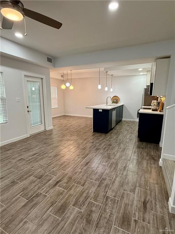 kitchen featuring visible vents, dark wood-style flooring, open floor plan, light countertops, and a ceiling fan