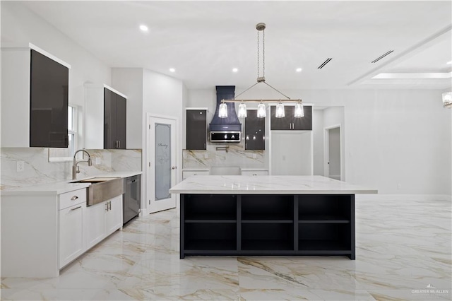 kitchen with pendant lighting, white cabinets, light stone countertops, appliances with stainless steel finishes, and a kitchen island