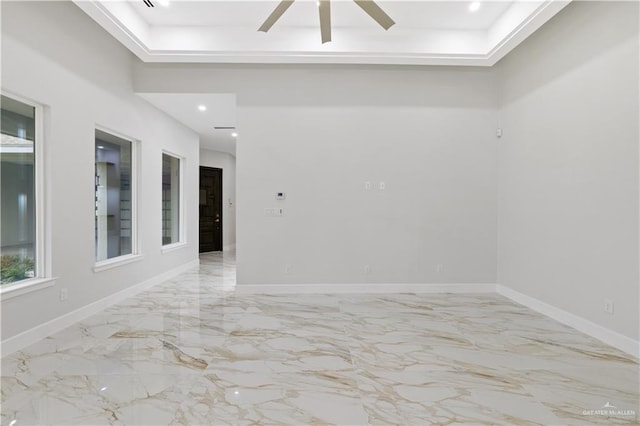 unfurnished room featuring a raised ceiling and ceiling fan