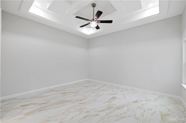 spare room with ceiling fan and a raised ceiling