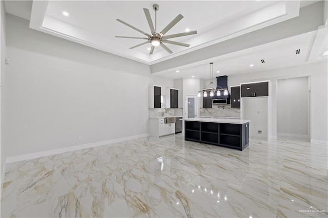 living room with a tray ceiling, ceiling fan, and sink