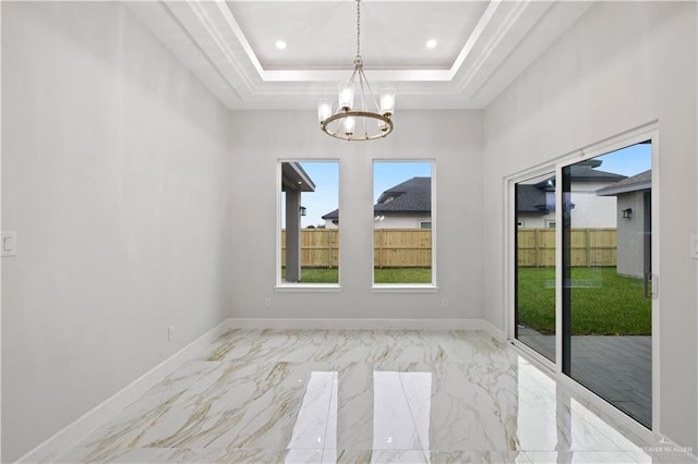 spare room featuring a chandelier and a raised ceiling