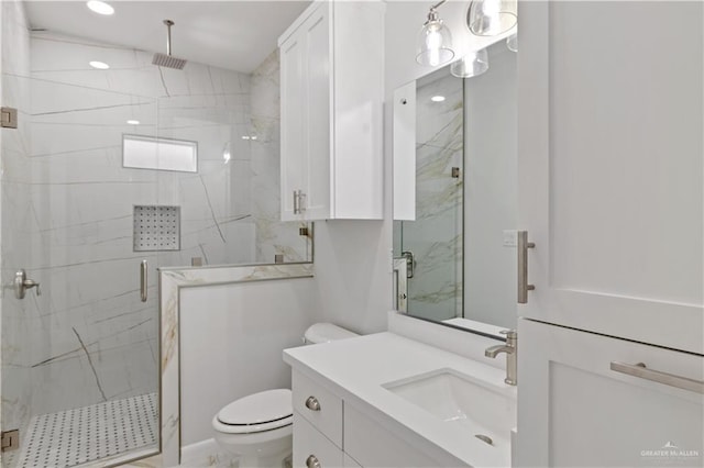 bathroom featuring a shower with door, vanity, and toilet