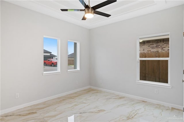 empty room with a tray ceiling and ceiling fan