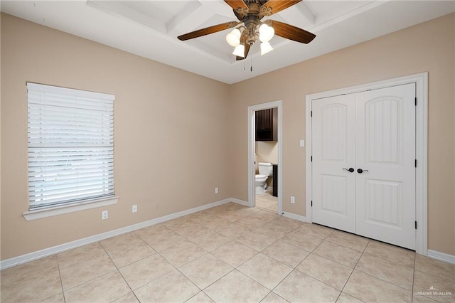 unfurnished bedroom featuring ceiling fan, light tile patterned floors, ensuite bath, and a closet