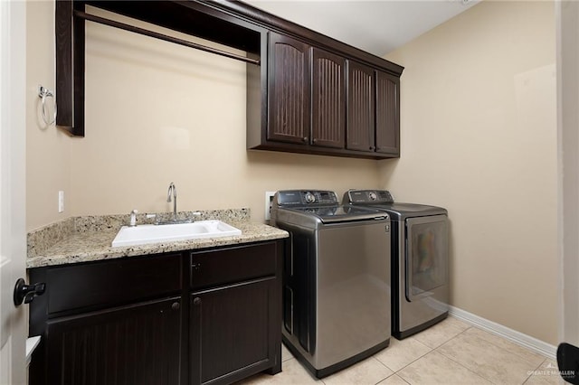 washroom featuring cabinets, washer and clothes dryer, sink, and light tile patterned floors