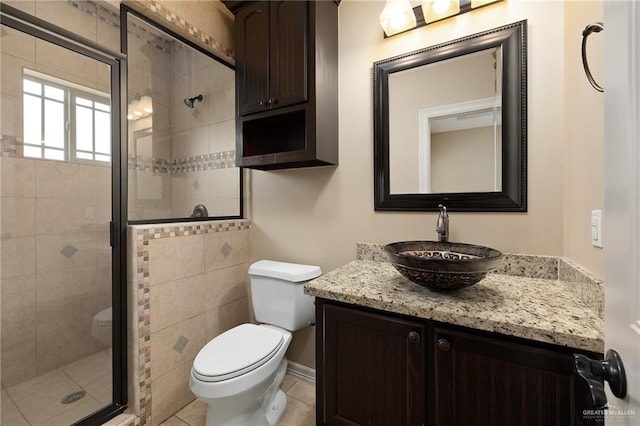 bathroom featuring vanity, tile patterned floors, a shower with door, and toilet