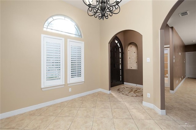 entryway featuring light tile patterned floors and a chandelier