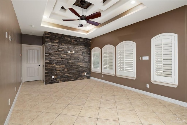 tiled spare room with a raised ceiling and ceiling fan