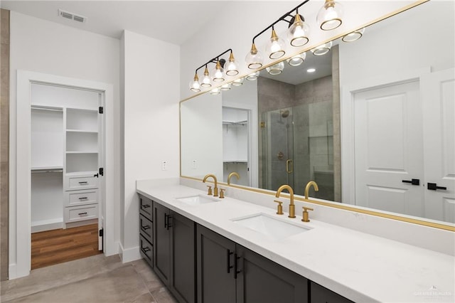 bathroom featuring a shower with shower door and vanity