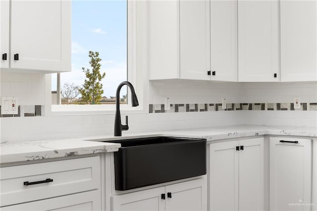 kitchen featuring white cabinets, decorative backsplash, and sink