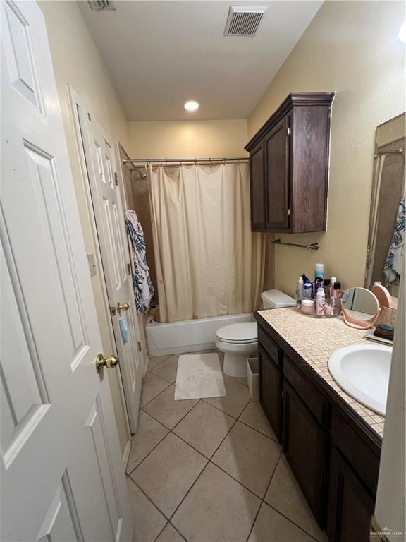 full bathroom featuring tile patterned floors, vanity, toilet, and shower / tub combo with curtain