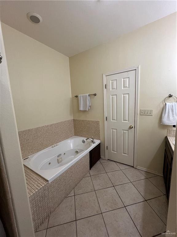 bathroom featuring vanity, a relaxing tiled tub, and tile patterned floors