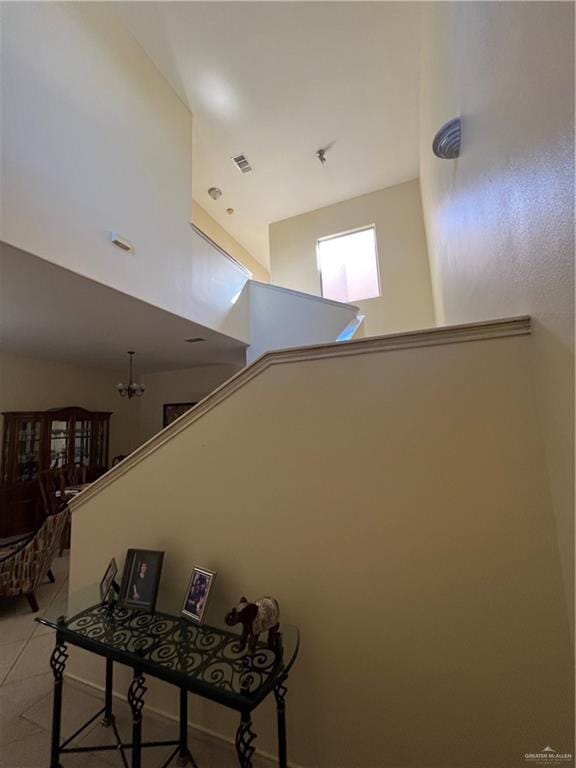 stairs with a high ceiling and a notable chandelier