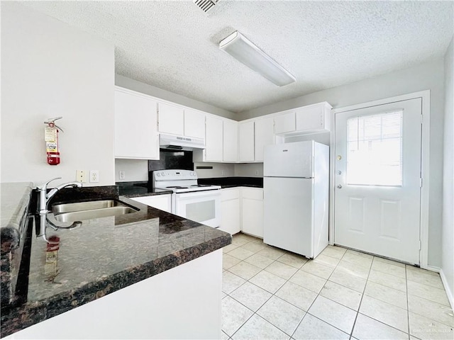 kitchen with light tile patterned floors, under cabinet range hood, white appliances, a sink, and white cabinetry