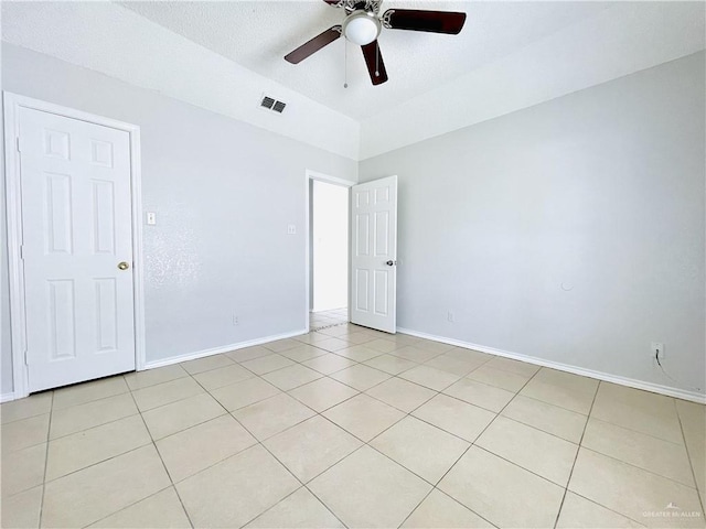 empty room with baseboards, light tile patterned flooring, visible vents, and a ceiling fan