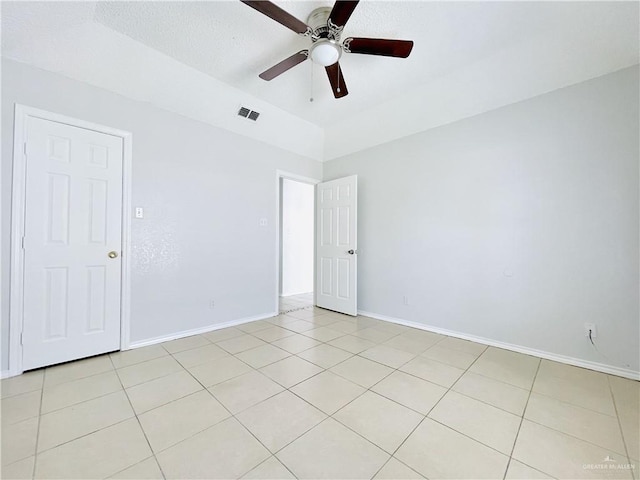 spare room featuring baseboards, visible vents, a ceiling fan, and light tile patterned flooring