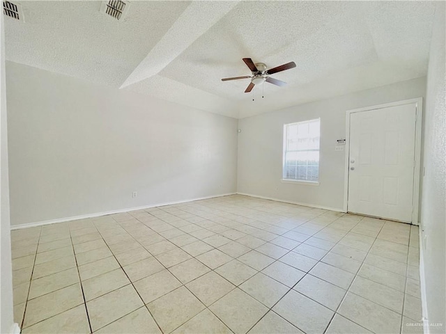 unfurnished room featuring light tile patterned floors, a textured ceiling, visible vents, and a ceiling fan