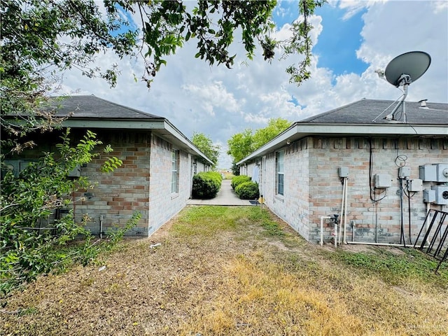 view of side of home with brick siding and a lawn