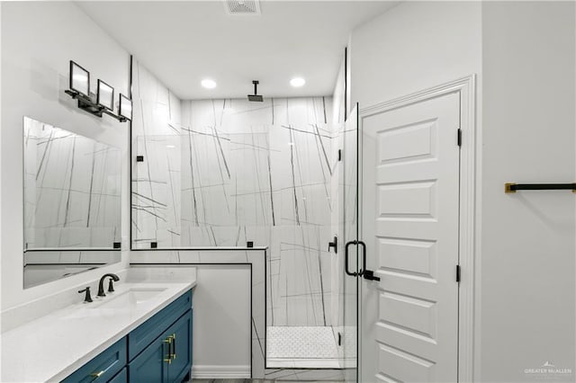 bathroom with a shower with door and vanity