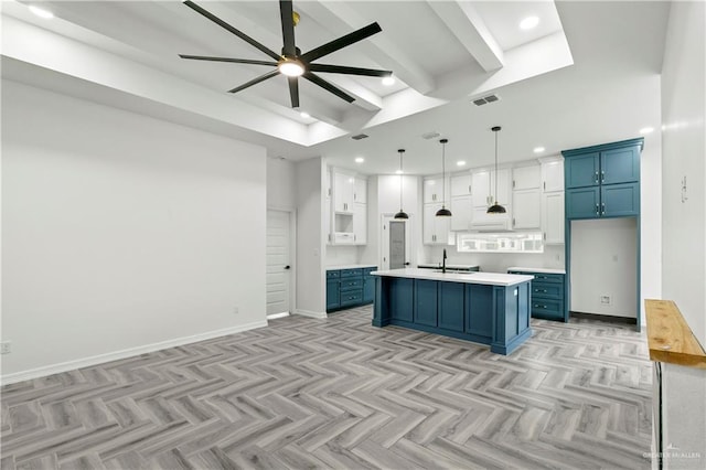 kitchen featuring blue cabinetry, light parquet floors, a center island with sink, and white cabinets