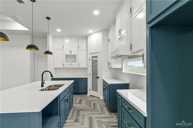 kitchen with decorative light fixtures, fridge, blue cabinetry, and white cabinets