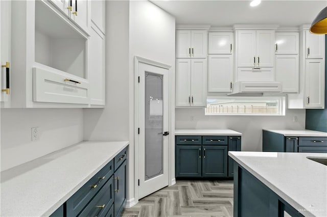 kitchen with light parquet flooring and white cabinets