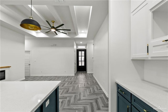 kitchen with blue cabinetry, white cabinetry, hanging light fixtures, ceiling fan, and light parquet floors