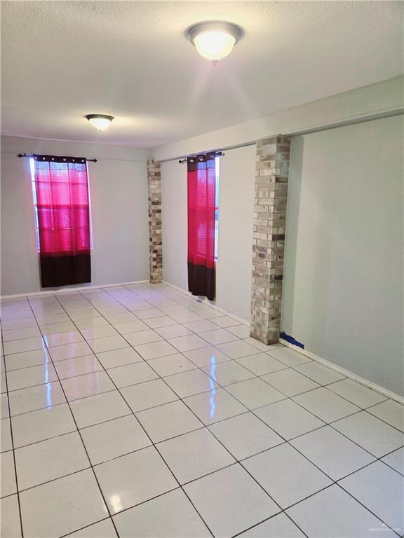 spare room with plenty of natural light, light tile patterned floors, and a textured ceiling