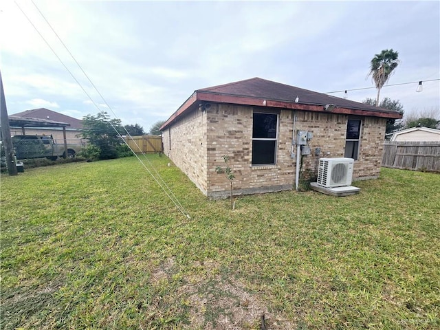 back of property with ac unit and a lawn