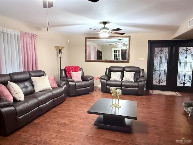 living area with a ceiling fan, french doors, visible vents, and wood finished floors