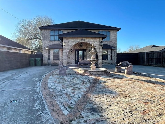 view of front of house with stone siding and fence