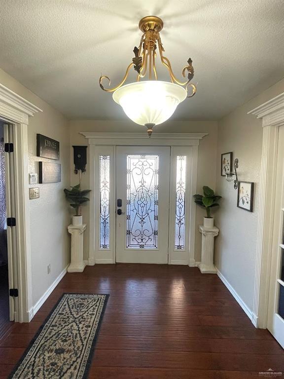 foyer with hardwood / wood-style flooring, plenty of natural light, and a textured ceiling