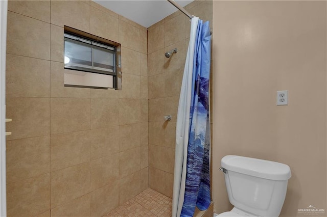 bathroom featuring curtained shower and toilet