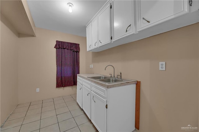 kitchen with white cabinets, light tile patterned floors, and sink