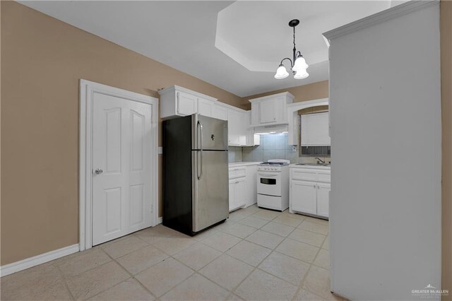 kitchen with white cabinets, decorative light fixtures, white range oven, and stainless steel refrigerator