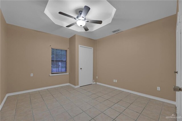 empty room with ceiling fan and light tile patterned flooring