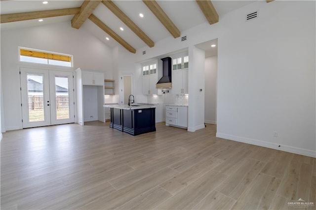 kitchen featuring visible vents, open floor plan, french doors, high vaulted ceiling, and wall chimney exhaust hood