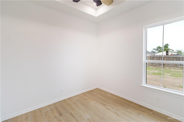 unfurnished room featuring ceiling fan, light wood-style floors, and baseboards