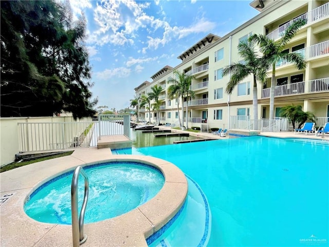 view of pool with a hot tub