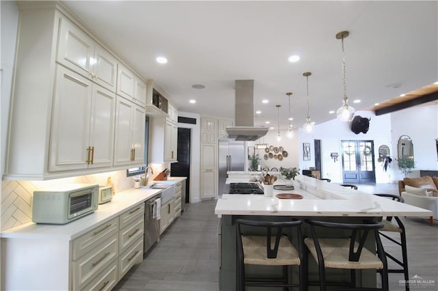 kitchen with decorative backsplash, island range hood, a spacious island, and appliances with stainless steel finishes