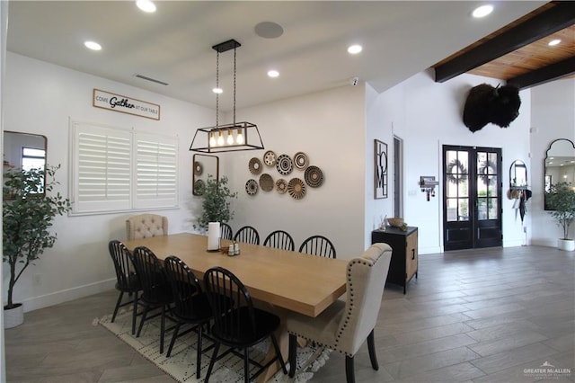 dining space with french doors, beamed ceiling, dark wood-type flooring, and plenty of natural light