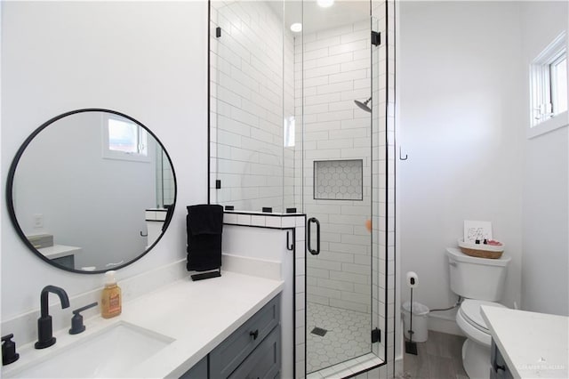 bathroom with an enclosed shower, vanity, toilet, and hardwood / wood-style floors