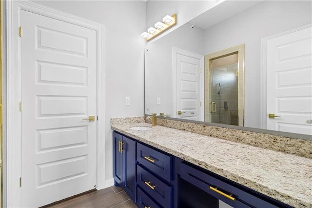 bathroom with wood-type flooring, vanity, and walk in shower